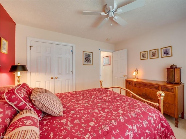 carpeted bedroom featuring a ceiling fan, a closet, and a textured ceiling