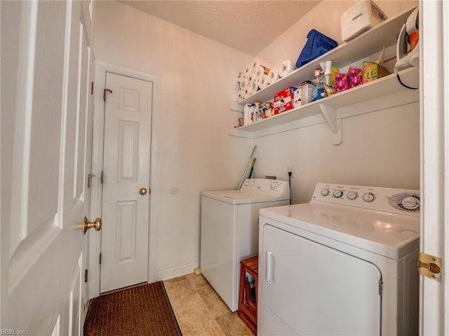 laundry area featuring laundry area, a textured ceiling, and washing machine and clothes dryer