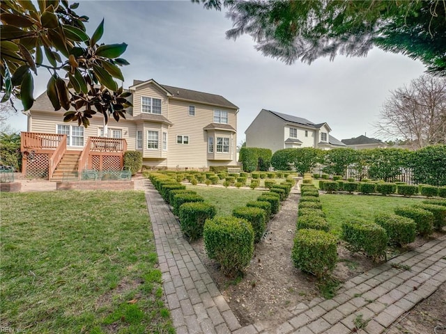 back of house with stairway, a lawn, and a wooden deck