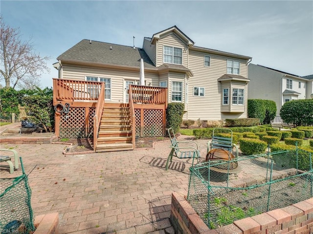 rear view of house with a patio, a shingled roof, stairway, fence, and a wooden deck