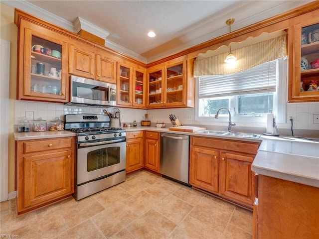 kitchen featuring decorative backsplash, glass insert cabinets, stainless steel appliances, light countertops, and a sink