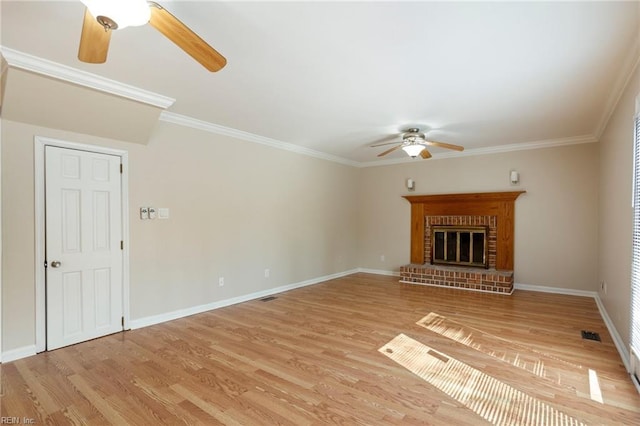 unfurnished living room featuring baseboards, a brick fireplace, light wood-type flooring, and crown molding