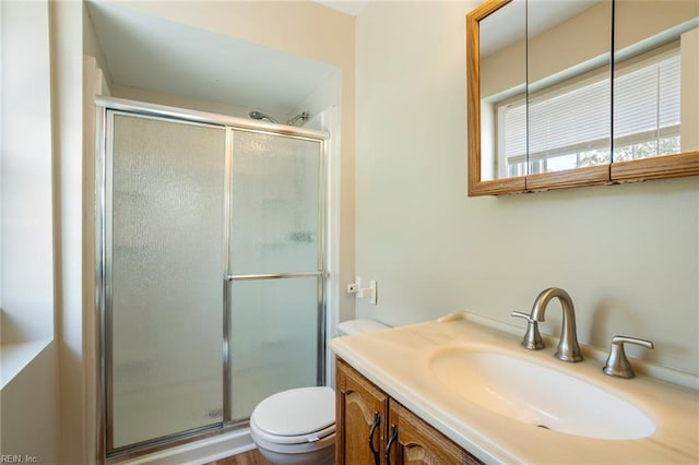 full bath with a stall shower, vanity, and toilet