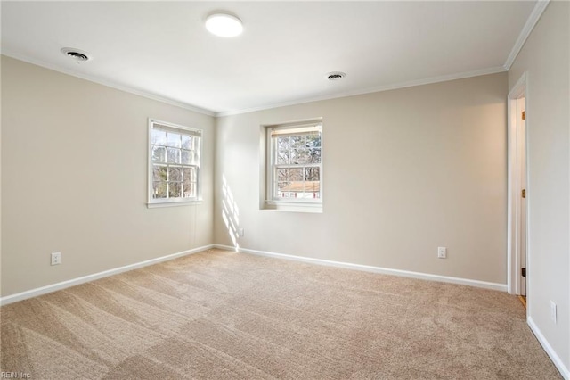 spare room featuring light carpet, ornamental molding, visible vents, and baseboards