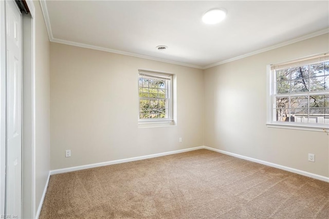 carpeted empty room featuring crown molding, visible vents, and baseboards