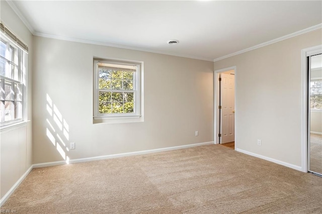 carpeted spare room featuring baseboards, ornamental molding, visible vents, and a healthy amount of sunlight