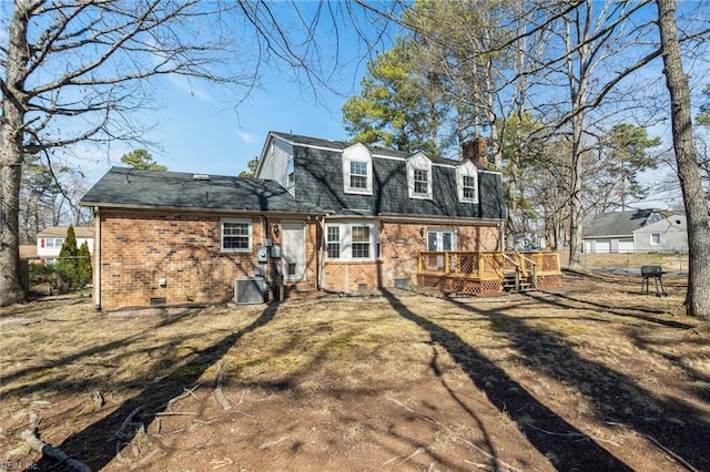 rear view of house featuring a deck, cooling unit, brick siding, crawl space, and a chimney