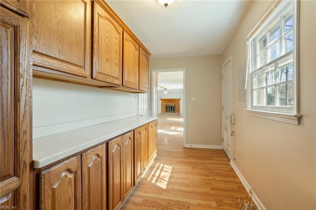 corridor with light wood-style flooring and baseboards