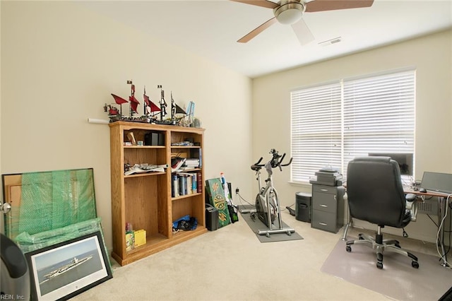 office featuring carpet flooring, visible vents, and a ceiling fan