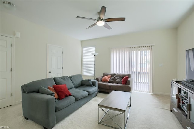 living room with light carpet, ceiling fan, and baseboards