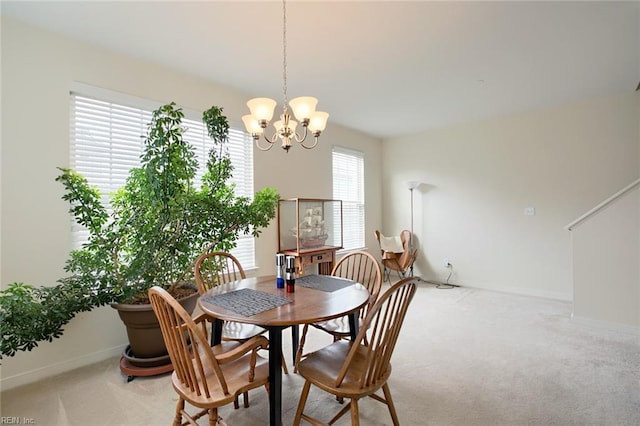 dining area featuring a chandelier, carpet floors, and baseboards