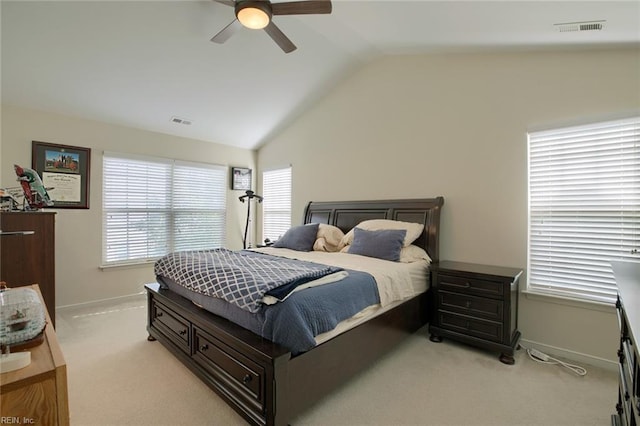 bedroom with multiple windows, visible vents, vaulted ceiling, and light colored carpet