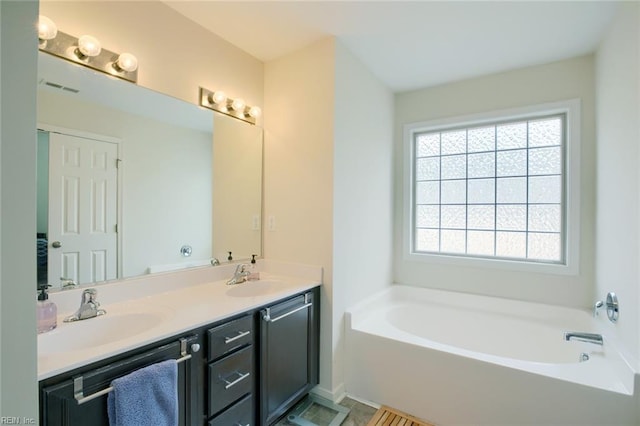 full bath with a bath, double vanity, visible vents, and a sink