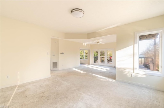 carpeted spare room featuring baseboards and visible vents