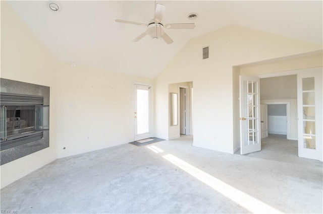 spare room with french doors, carpet, a glass covered fireplace, and visible vents