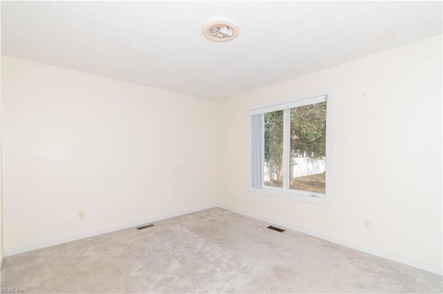 empty room with baseboards, visible vents, and carpet flooring