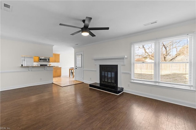 unfurnished living room with ornamental molding, dark wood-style flooring, and visible vents