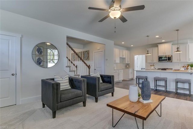 living room with a ceiling fan, recessed lighting, baseboards, and stairs