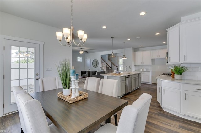 dining area with stairs, ceiling fan with notable chandelier, dark wood-style flooring, and recessed lighting