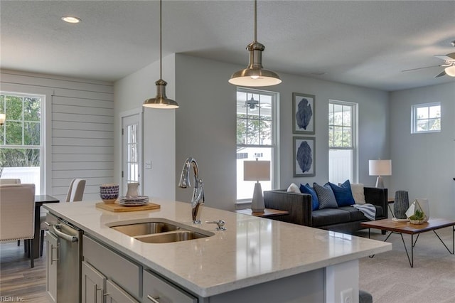 kitchen with a ceiling fan, open floor plan, a sink, and a textured ceiling