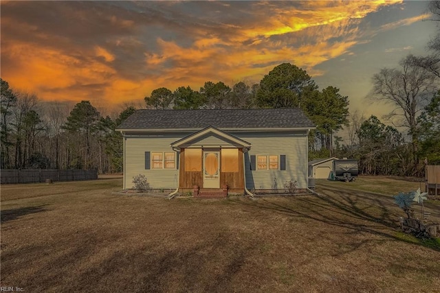 view of front of property with an outdoor structure, a front lawn, and fence