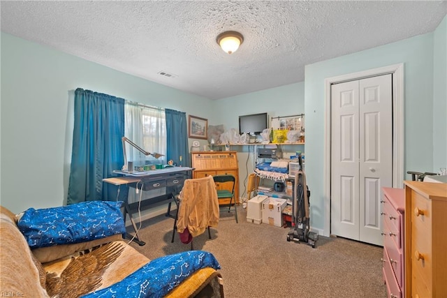 carpeted bedroom with a closet, visible vents, and a textured ceiling