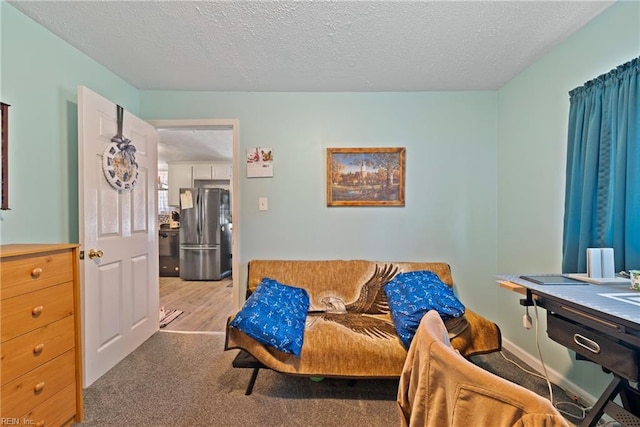 carpeted living room featuring a textured ceiling