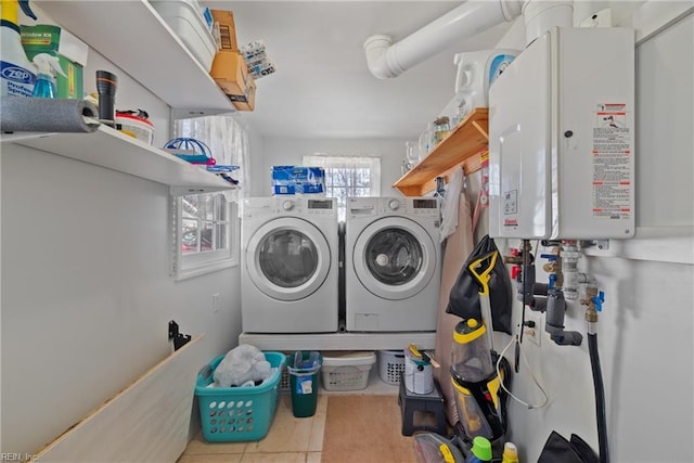 laundry area featuring water heater, laundry area, tile patterned floors, and washer and dryer