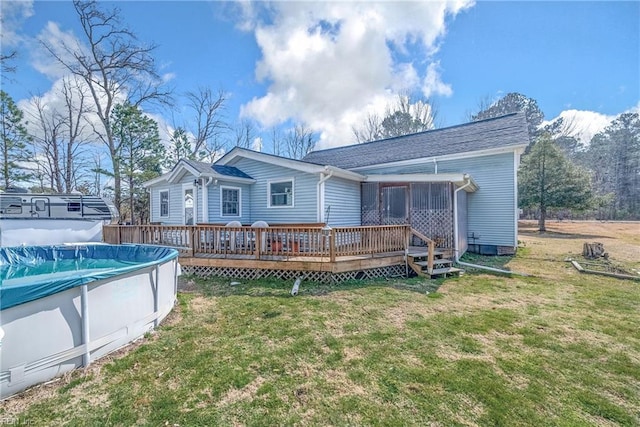 back of house with a deck, a lawn, and a fenced in pool