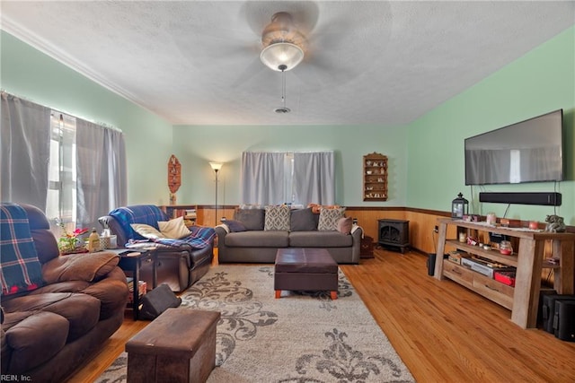 living room with wainscoting, a textured ceiling, and wood finished floors