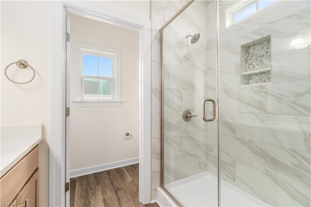 full bath featuring a wealth of natural light, a stall shower, vanity, and wood finished floors