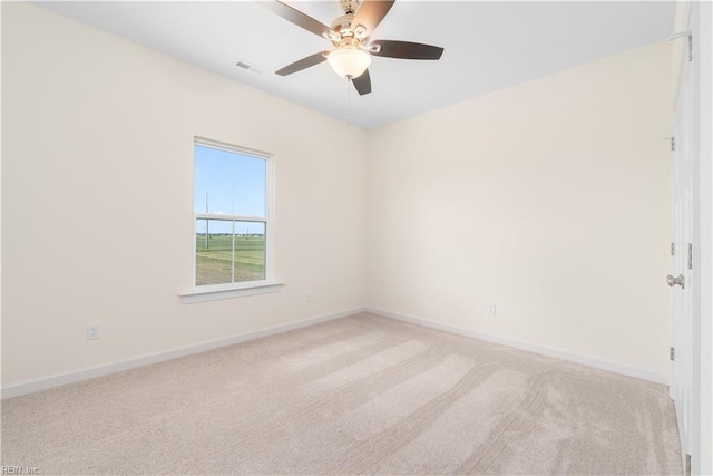 empty room with ceiling fan, carpet flooring, visible vents, and baseboards