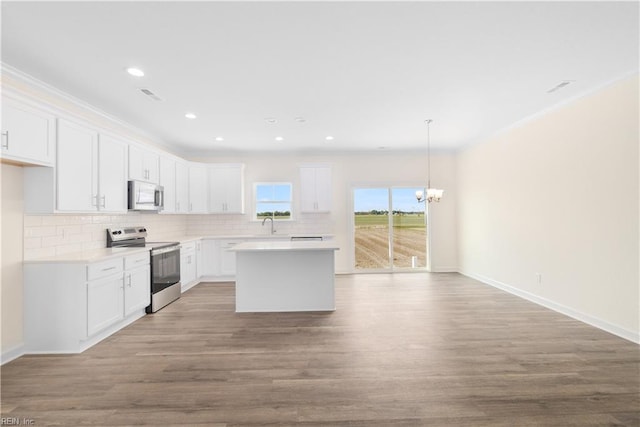 kitchen with stainless steel electric range oven, wood finished floors, and decorative backsplash