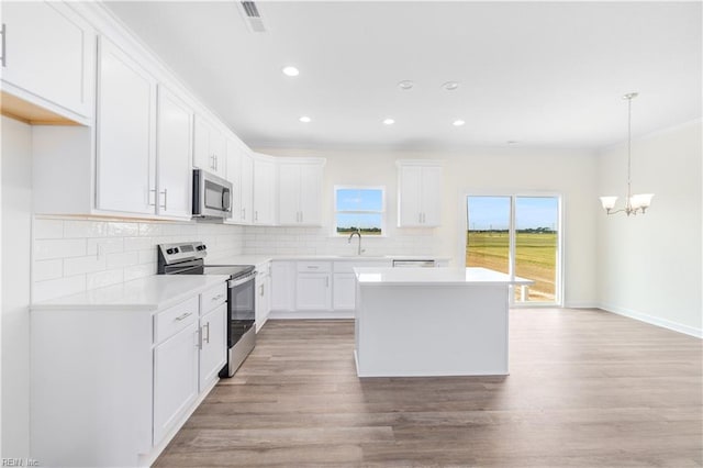 kitchen with stainless steel appliances, tasteful backsplash, a sink, and light wood-style floors