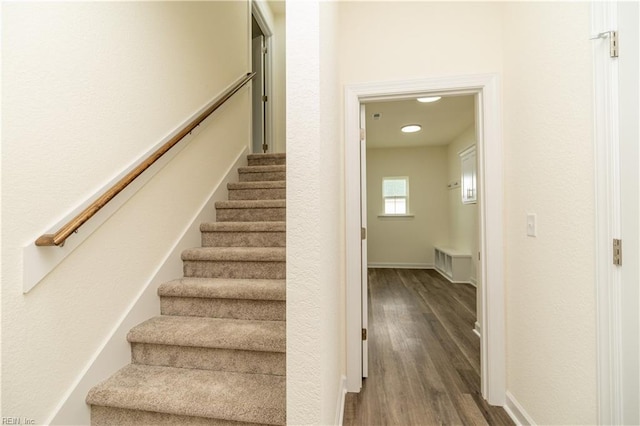 stairway featuring wood finished floors and baseboards