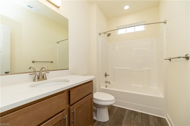 bathroom featuring visible vents, toilet, vanity, shower / tub combination, and wood finished floors