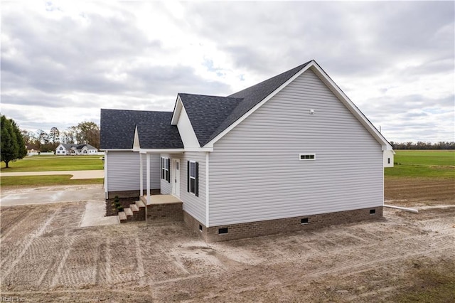 view of property exterior featuring crawl space and roof with shingles