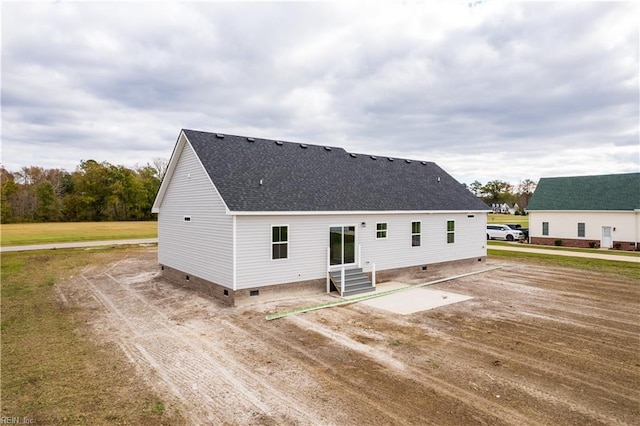 rear view of house featuring entry steps, a patio, a shingled roof, and crawl space