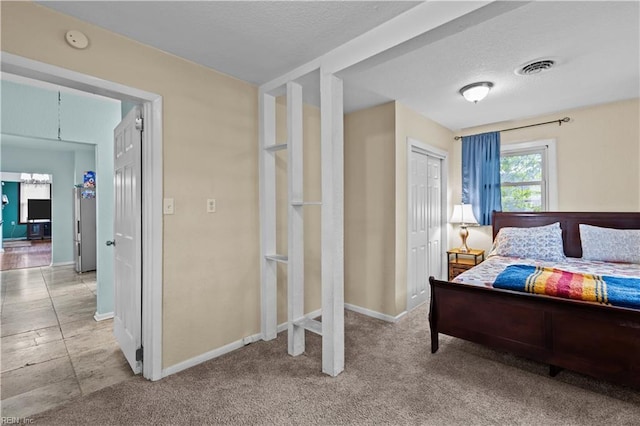 bedroom with a closet, visible vents, a textured ceiling, and baseboards