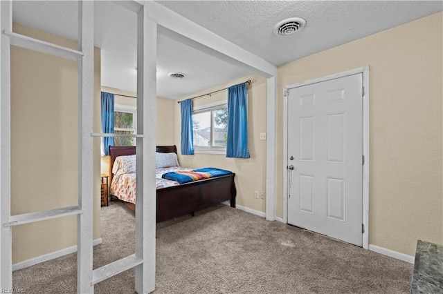 bedroom featuring baseboards, carpet, visible vents, and a textured ceiling