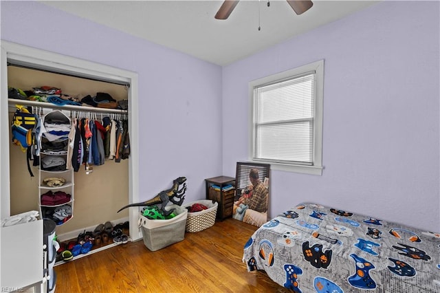 bedroom featuring a closet, wood finished floors, and a ceiling fan