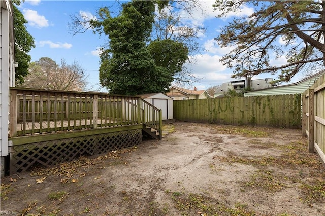 view of yard with a fenced backyard, an outdoor structure, a deck, and a shed