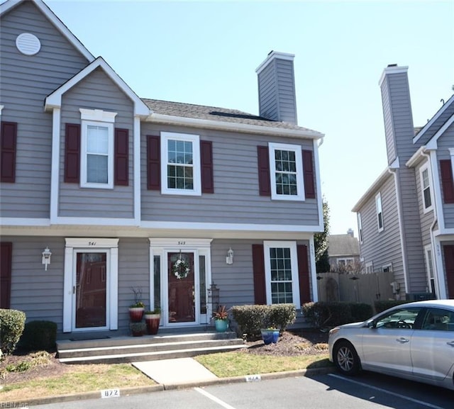 view of front of home with uncovered parking and a chimney