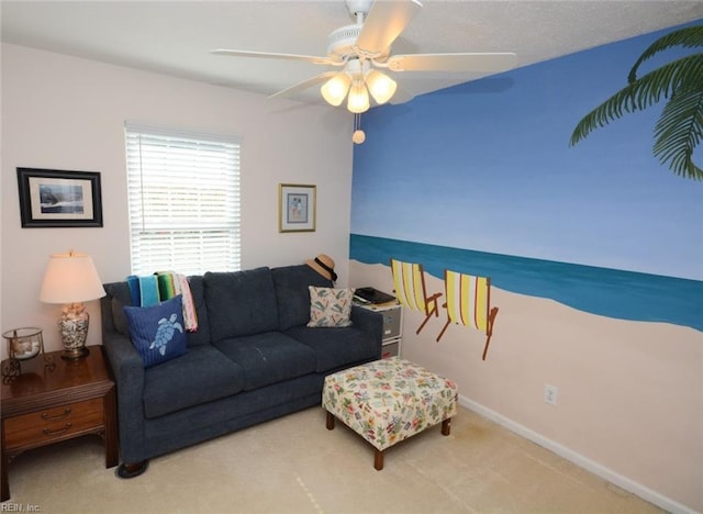 carpeted living area with baseboards and a ceiling fan