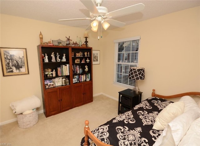 bedroom featuring carpet floors, a textured ceiling, baseboards, and a ceiling fan