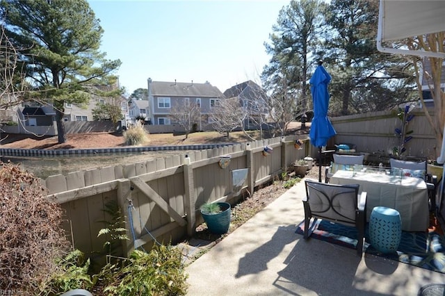 view of patio featuring a fenced backyard, a residential view, and outdoor dining space