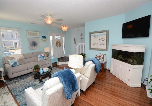 living room with visible vents, ceiling fan, and wood finished floors