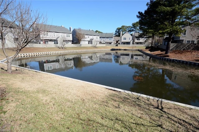 dock area with a lawn, a water view, and a residential view