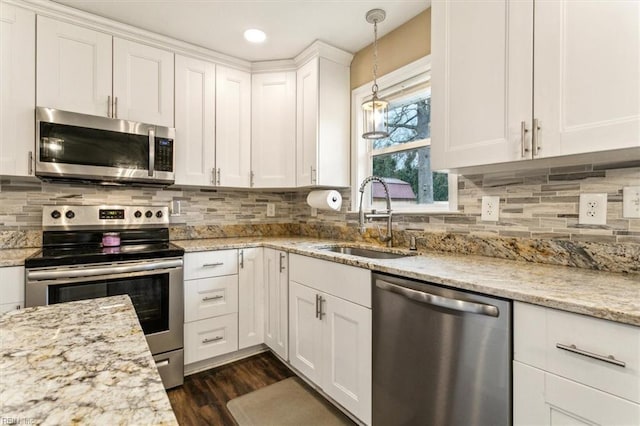 kitchen featuring a sink, white cabinetry, appliances with stainless steel finishes, dark wood-style floors, and tasteful backsplash