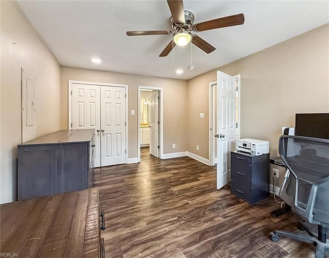 office area featuring dark wood-type flooring, ceiling fan, and baseboards